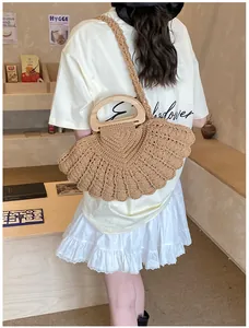 Close-up of brown woven fan-shaped tote bag with wooden handle and slim shoulder strap
