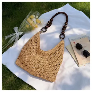Detail of hollow woven beach bag featuring vintage wood bead handles and beige knit texture