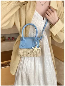 Detail of blue leather and beige straw patchwork mini bag with starfish charms