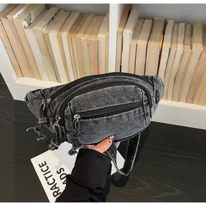 Close-up of vintage grey washed denim fanny pack with multi-zipper compartments