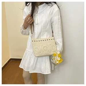 Detail of bohemian crochet crossbody bag with floral patterns and brown leather strap