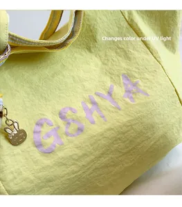 Detalle del bolso amarillo con tela que cambia de color con rayos UV y colgante de conejo