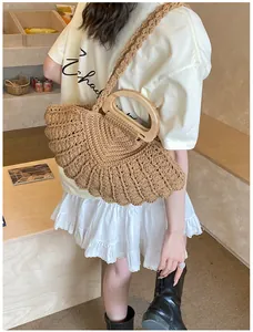 Detail of fan-shaped woven handbag with natural wooden handle in bohemian style