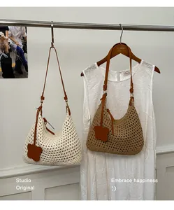 Detail view of woven shoulder bags in beige and khaki with leather floral charms
