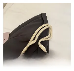 Detail showing the woven strap and floral crochet texture of the beige shoulder bag