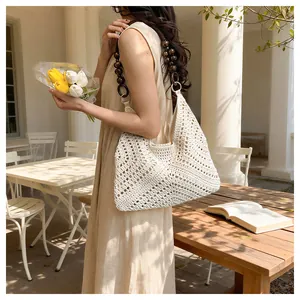 Detail of hollow woven shoulder bag with dark wooden bead straps and diamond crochet pattern