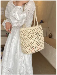 Detail of hand-crocheted floral tote bag with openwork daisy patterns in cream white