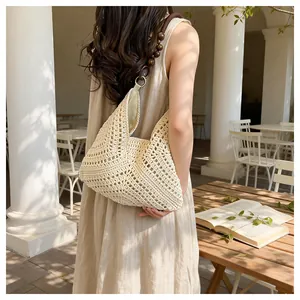 Detail of crochet knit beach bag with dark brown wood beads on the shoulder strap