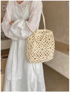 Detail of hollow-out daisy crochet pattern on a beige bohemian woven shoulder bag