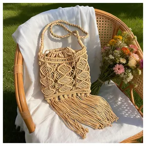 Detail of bohemian macrame straw bag with tassels and interior drawstring lining