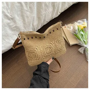 Detail of bohemian straw bag with floral woven patterns and decorative wooden beads