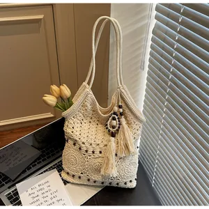 Dettaglio della borsa tote in maglia bohémien con motivo all'uncinetto e nappa con perline