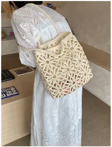Detailed close-up of hollow flower crochet pattern on cream cotton woven shoulder bag
