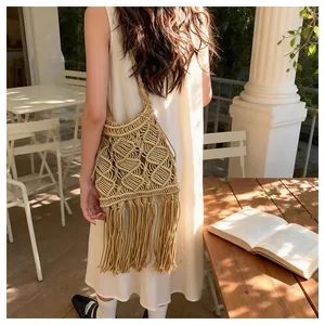 Detail of bohemian woven tassel shoulder bag with geometric hollow patterns on terrace