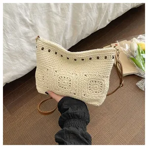Detail of crochet straw bag with brown bead accents and adjustable leather strap