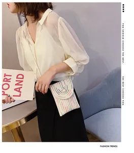 Détail du mini sac bandoulière tissé avec motifs ondulés colorés et décoration de perle