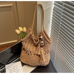 Dettaglio della borsa tote intrecciata con trama floreale, ciondolo a nappa e tulipani