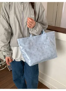 Detail of light blue waterproof jelly tote bag with laser-cut hollow pattern and PVC layer