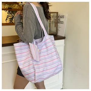 Detalle de bolso tote de lona a rayas con mini neceser a juego y de gran capacidad