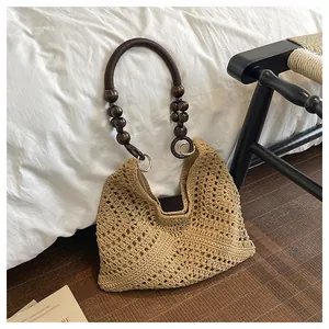 Detail of hand-woven crochet tote bag featuring vintage dark brown beaded handles