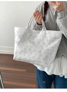 Detailed view of white laser-cut floral tote bag with waterproof clear PVC coating