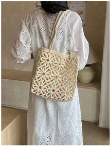 Macro detail of beige crochet tote bag showing hollow floral patterns and woven texture