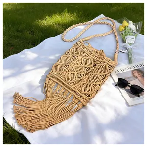 Close-up of bohemian woven straw bag featuring hollow diamond patterns and long tassels