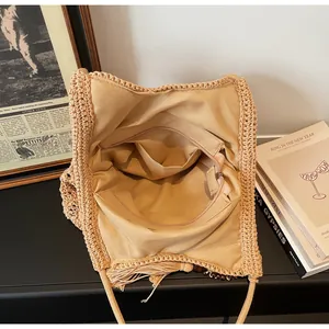 Dettaglio dell'interno della borsa in maglia con tasche a zip e fodera in cotone beige