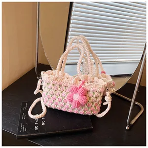 Nahaufnahme der handgehäkelten Tulpen-Tasche mit Perlenverschluss und Blumenanhänger