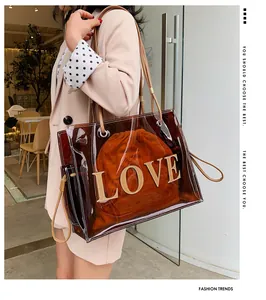 Detail of transparent brown PVC tote with gold LOVE lettering and orange inner pouch