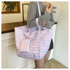 Detalle de bolso tote a rayas con mini neceser a juego y vista de la textura física