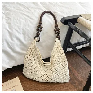Detailed close-up of hollow woven beige tote with wooden beads and boho texture