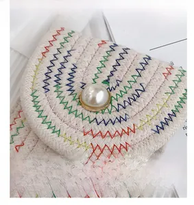 Vue détaillée du sac à bandoulière tissé avec bouton perle et broderie zigzag colorée