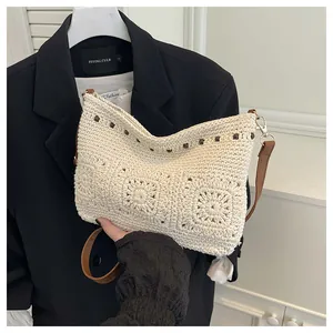 Detailed view of bohemian crochet bag with dark beads and brown leather shoulder strap