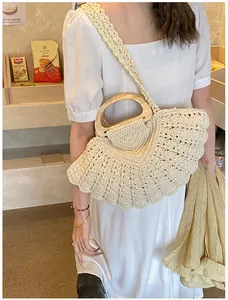 Detail of hand-woven shell bag with wooden handles and beige crochet patterns