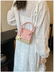 Détail du sac rose en cuir et paille avec charm étoile de mer sur robe en dentelle