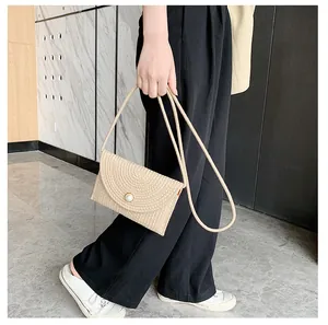 Détail du sac bandoulière en paille avec texture spirale et fermoir perle