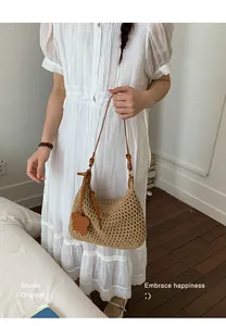 Detail of hand-woven straw shoulder bag with leather strap and cute bear charm pendant