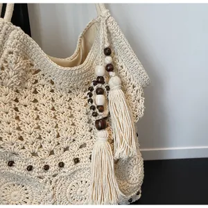 Dettaglio della borsa tote all'uncinetto con motivi geometrici e perline di legno
