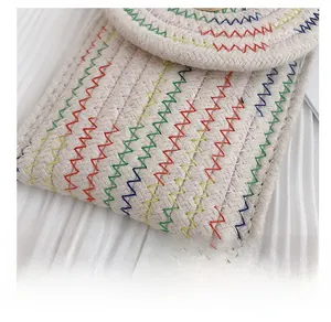 Détail du sac bandoulière tissé en coton avec surpiqûres arc-en-ciel et texture douce