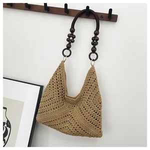 Close-up of woven hollow bag featuring dark brown wooden bead and ring handle detail
