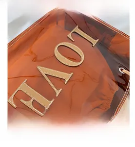 Detailed macro view of orange transparent PVC tote with leather LOV letter applique