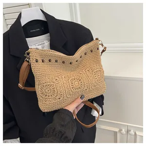 Close-up of bohemian woven bag with crochet flowers and studs on a black blazer