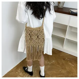 Detail of bohemian macrame crossbody bag featuring long tassels and geometric weave pattern
