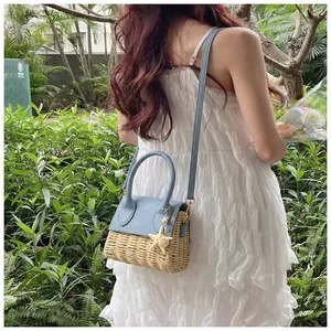 Detailed shot of mini straw bag with light blue leather flap and starfish charm accessory
