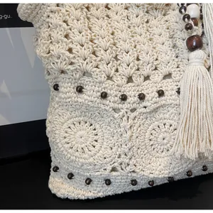 Dettaglio della borsa tote in maglia lavorata a mano con perline e lunghe frange