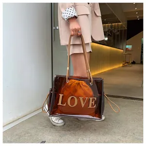 Detail view of a transparent brown PVC tote bag with orange pouch and LOVE lettering