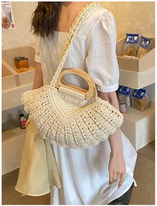 Detail of hand-woven cream cotton bag featuring fan-shaped texture and wooden handles