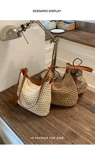 Detail of hand-woven mesh shoulder bags with brown leather straps on a wooden table