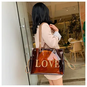 Detail of transparent brown tote bag with LOVE lettering and orange drawstring inner bag